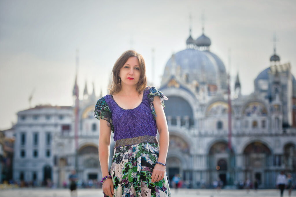 Woman in purple top and floral skirt outside